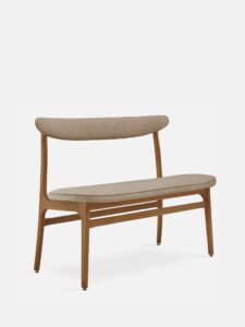 De 200-190 Bank Boucle Beige Dark Wood heeft een minimalistisch ontwerp met strakke lijnen, een frame van donker hout en een met lichtbeige boucle beklede zitting en rugleuning tegen een effen witte achtergrond.