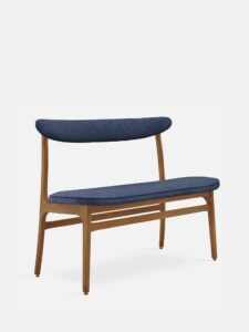 De 200-190 Bench Boucle Denim Dark Wood heeft een modern houten frame, een gebogen rugleuning en een zitting bekleed met donkerblauwe boucle-stof tegen een effen witte achtergrond.