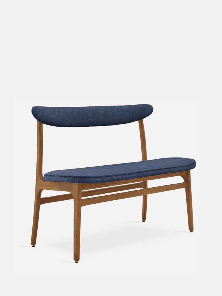De 200-190 Bench Boucle Denim Dark Wood heeft een modern houten frame, een gebogen rugleuning en een zitting bekleed met donkerblauwe boucle-stof tegen een effen witte achtergrond.