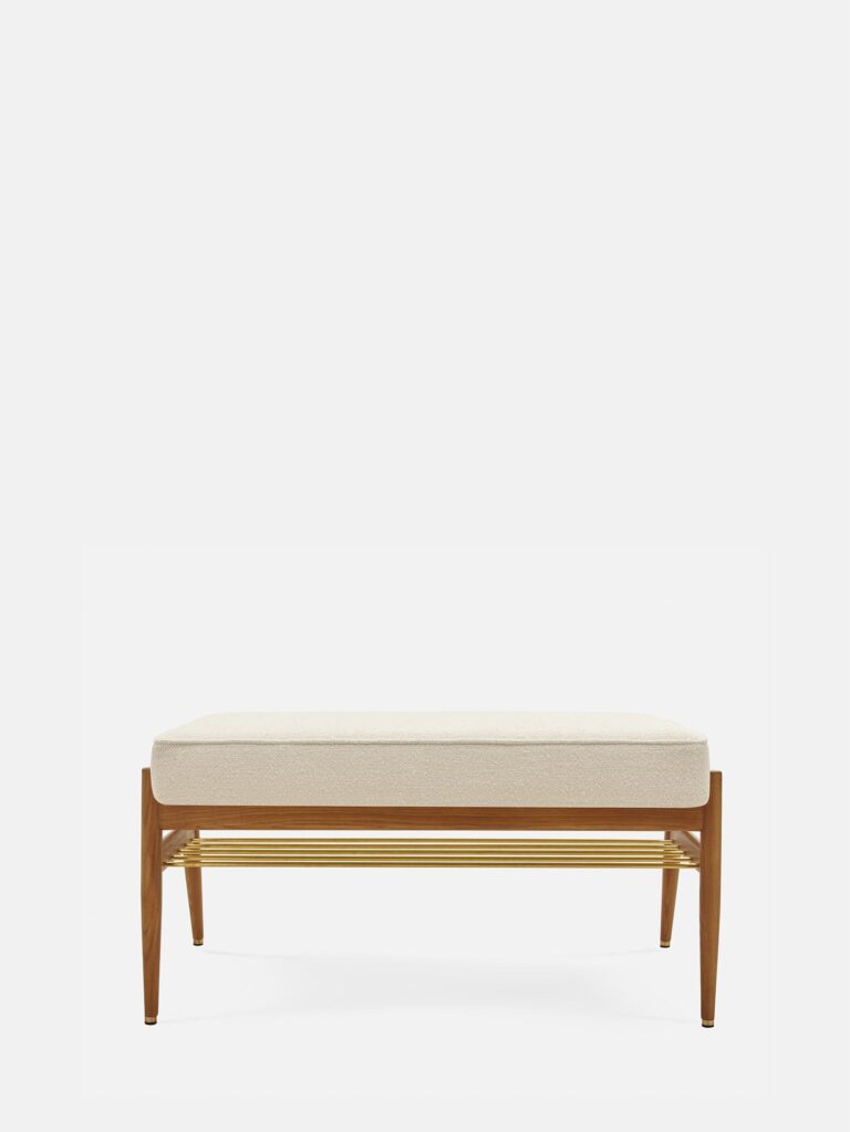 De FOX Bench 90 heeft een zitting met boucle crèmekleurige kussens, een frame van donker hout en een blad van goudkleurig metaal met latten tegen een effen witte achtergrond.