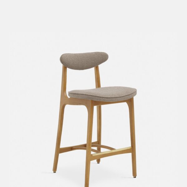 De 200-190 Barkruk S/65 heeft een modern ontwerp met een gebogen, met beige boucle beklede zitting en rugleuning, eenvoudige, strakke lijnen en schuin geplaatste poten van natuurlijk hout, tegen een effen witte achtergrond.