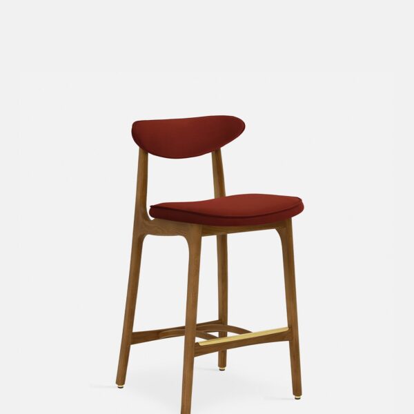 De 200-190 Barkruk S/65 heeft een gebogen rugleuning en zitting bekleed met fluweelrode baksteenstof, ondersteund door donkerhouten poten met een voetsteun. Het minimalistische, op het midden van de eeuw geïnspireerde ontwerp voegt moderne stijl toe aan elke ruimte.