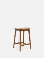 De 200-190 Barkruk Basic M/75 Timber ND Dark Wood heeft een gebogen houten zitting, vier poten en een goudkleurige voetsteun tegen een effen witte achtergrond.