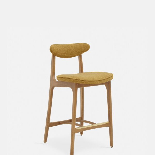 De 200-190 Barkruk M/75 heeft een modern frame van natuurlijk hout, een gebogen rugleuning en een mosterdgele, met bouclé beklede zitting en rugleuning, afgebeeld op een effen witte achtergrond.