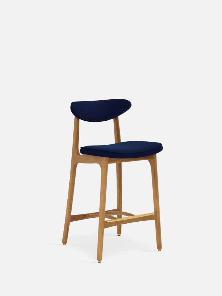 De 200-190 Barkruk M/75 heeft natuurlijk hout en een gebogen rugleuning met een zitting bekleed met indigo fluweel, tegen een effen witte achtergrond.