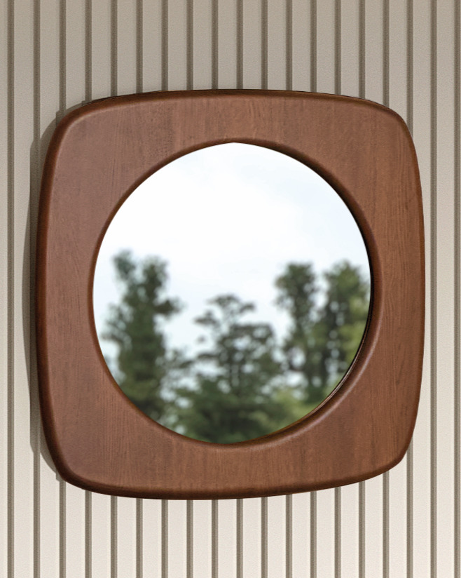 De SENTO SPIEGEL90 EL21, een ronde spiegel met een dikke vierkante houten lijst, is gemonteerd op een verticaal gestreepte beige muur en weerspiegelt bomen en een bewolkte lucht buiten.