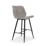De Barkruk Borgo zwart Stof Soft Pebble is een moderne barkruk met een beklede, lichtgrijs gestoffeerde zitting en rugleuning, vier slanke zwarte metalen poten en een voetsteun aan de voorkant. Gefotografeerd tegen een witte achtergrond.