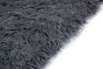 Close-up van het Merano Charcoal 013 200x300 tapijt met donkergrijze kleur, ruige textuur en lange vezels tegen een witte achtergrond.