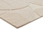 Een close-up van het Bolsena Beige 170x230 vloerkleed, dat zacht aanvoelt en een modern abstract patroon heeft met verhoogde, gebogen vormen in een neutrale beige kleurstelling.
