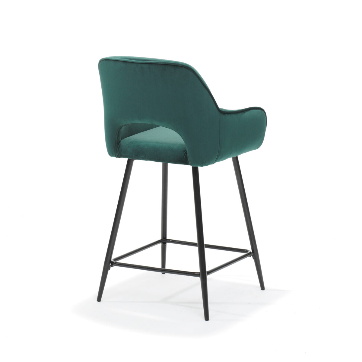 De Katy barkruk zwart - Stof Velours Groen is een moderne groene fluwelen barkruk met een gebogen rugleuning, armleuningen en zwarte metalen poten, afgebeeld schuin van achteren links.