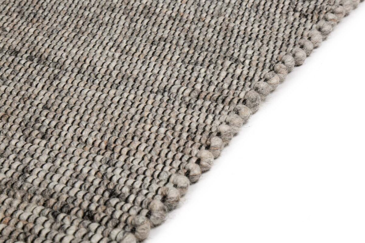 Close-up van het tapijt Bressano Grey 834 200x300, met een geweven, gestructureerd lussenpatroon en een dikke, afgeronde rand, tegen een witte achtergrond.