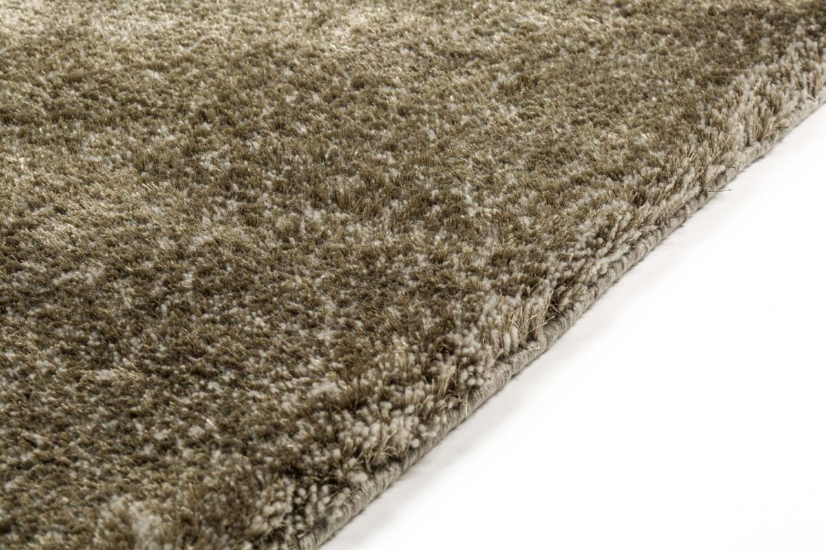 Close-up van de rand van een dik, pluche Viterbo ST Dark Grey 831 200x300 tapijt met een zacht, gestructureerd oppervlak, getoond tegen een witte achtergrond.
