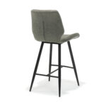 De Barkruk Borgo zwart Stof Soft Steel heeft een modern ontwerp met een grijze beklede zitting en rugleuning, zwarte taps toelopende metalen poten en een voetensteun, die schuin vanaf de rug tegen een witte achtergrond wordt weergegeven.