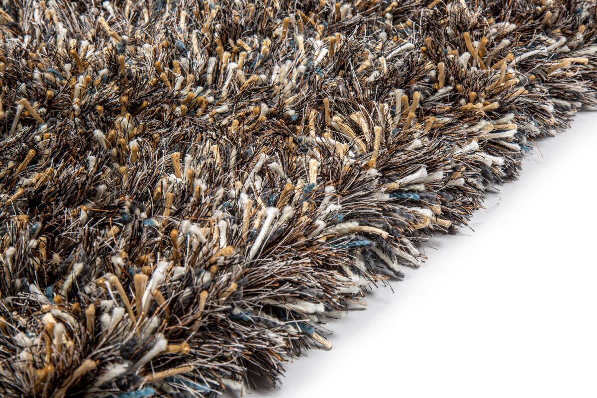 Close-up van het New Paulo Dark Blue/Bronze 270 vloerkleed (170x230), met dikke, getextureerde vezels in bruin-, beige-, wit- en blauwtinten. De afbeelding benadrukt de pluche, dichte pool tegen een witte achtergrond.