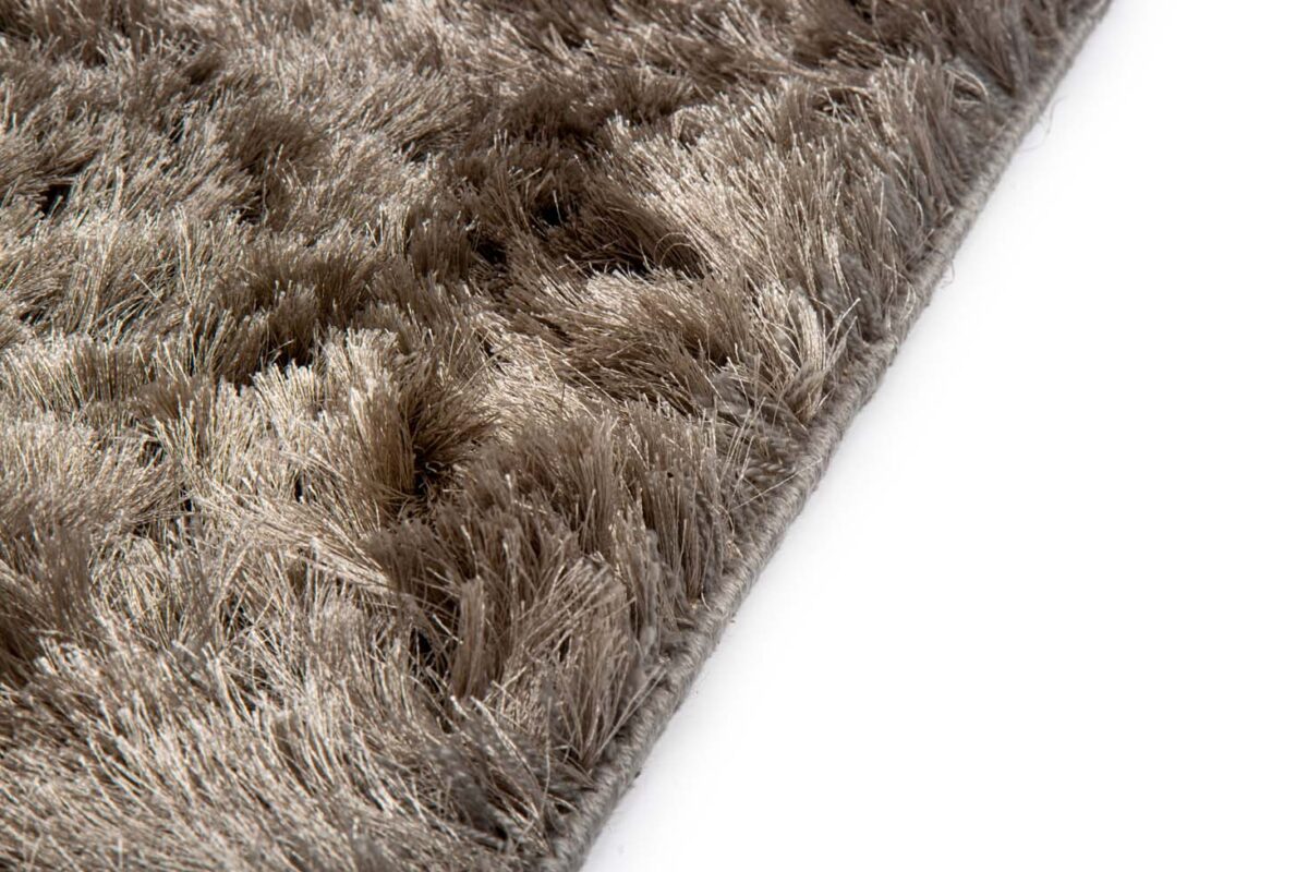 Close-up van de shaggy vezels met zachte textuur van het Arezzo ST Grey 803 200x300 tapijt op een witte achtergrond, waarbij het pluche grijze oppervlak wordt benadrukt voor extra comfort en gezelligheid.