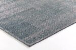 Een close-up van het Cirix dessin 2301 Sea blue 160x230 vloerkleed toont een geweven structuurpatroon in gedempte blauwe en grijze tinten, netjes afgewerkte randen met stiksels tegen een witte achtergrond.