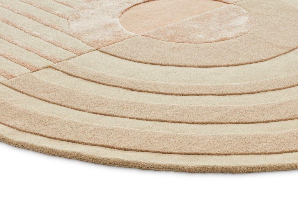 De Fano Girare White Beige ø320 is een rond tapijt in beige en wit met een modern geometrisch ontwerp van concentrische cirkels en rechte lijnen, waardoor een getextureerd, verhoogd patroon ontstaat.