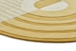 De Fano Girare Wild Wonder ø320 is een rond, modern vloerkleed in crème en mosterdgeel, met geometrische concentrische bogen en rechte lijnen voor een getextureerde, abstracte look.