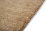 Close-up van het San Stefano Light Beige 07 200x300 tapijt met de pluche, getextureerde pool en zacht afgeronde randen, geplaatst op een wit oppervlak.
