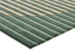 Een close-up van het Fano Green 300x400 rechthoekige vloerkleed met opstaande, getextureerde strepen in afwisselend saliegroen en beige, schuin tegen een witte achtergrond.