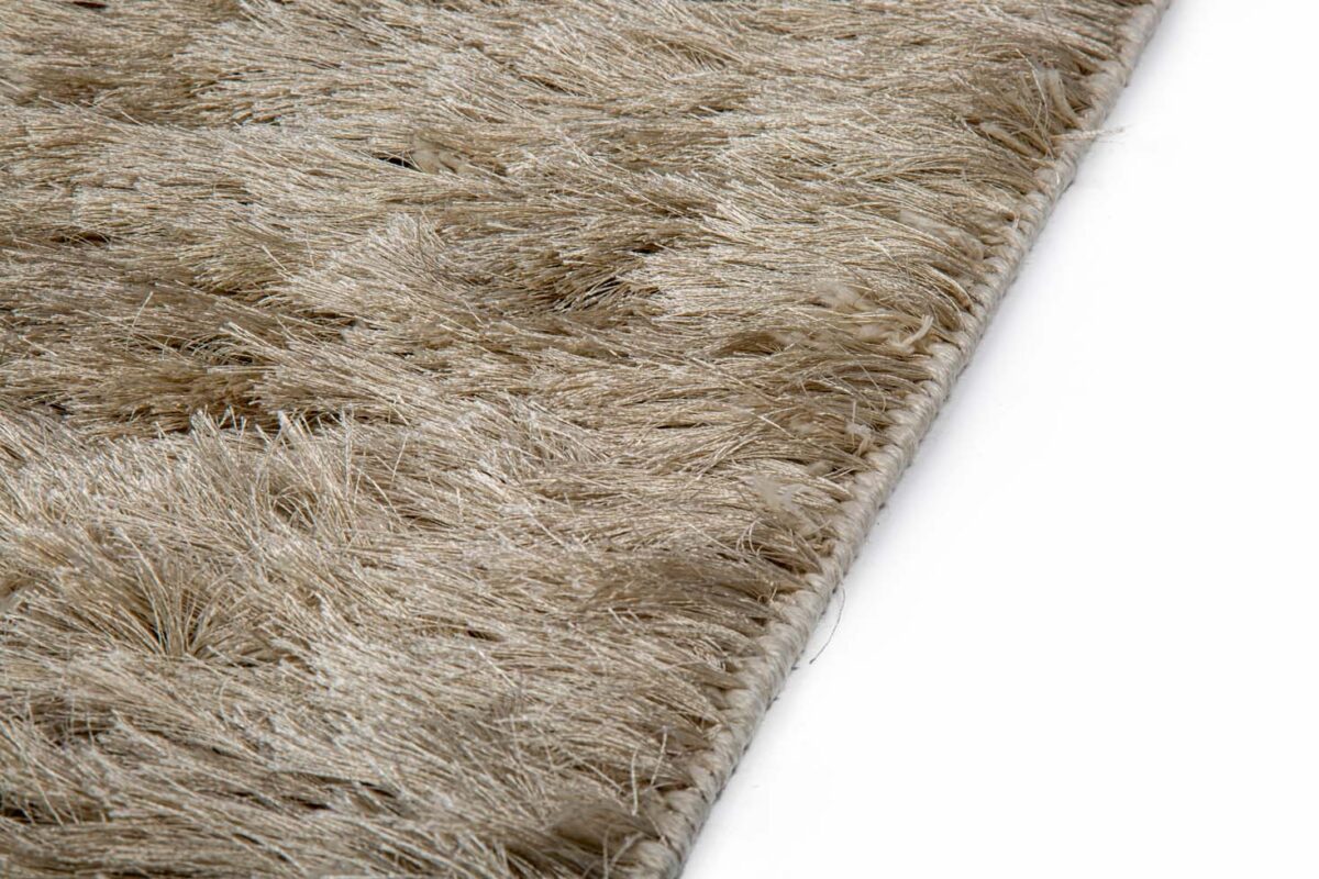 Close-up van het Arezzo ST Silver 119 200x300 tapijt, met de lange, zachte beige vezels en gestructureerde details tegen een witte achtergrond.