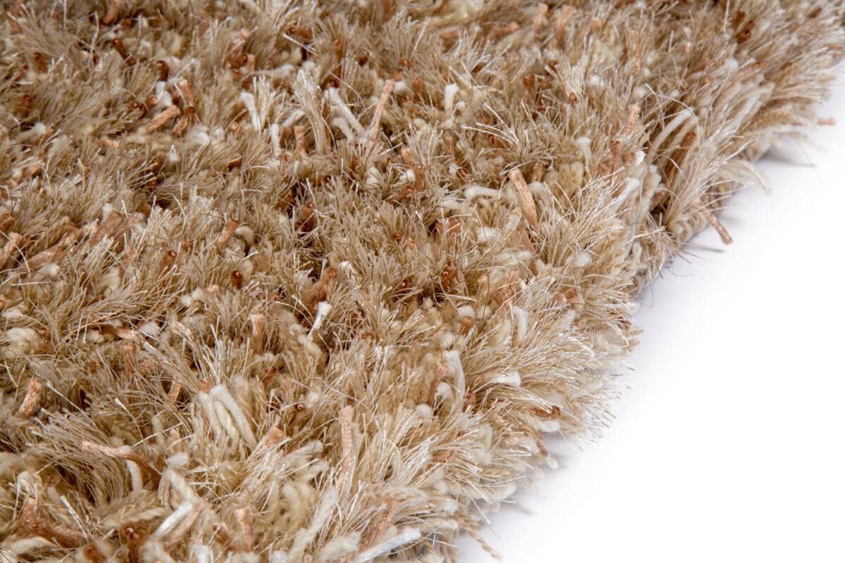 Close-up van het New Paulo Light Beige mix 126 vloerkleed (200x300 cm), met lange, dikke en ongelijkmatige beige vezels tegen een witte achtergrond.