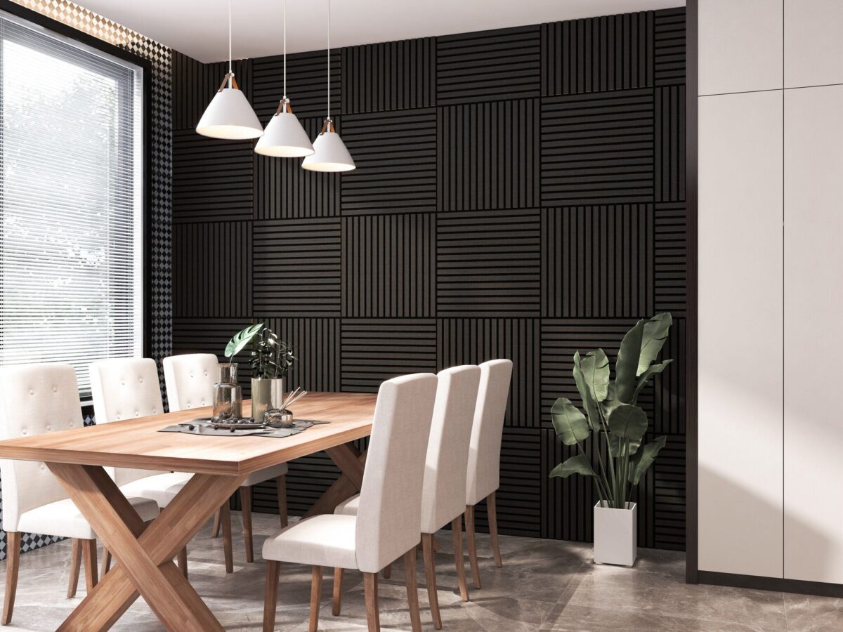 Moderne eetkamer met een Akupanel Eiken Zwart 60 x 60 cm lattenwand akoestische wandpanelen op de accentmuur, een houten tafel, zes wit gestoffeerde stoelen, hanglampen, een potplant en jaloezieën die natuurlijk licht binnenlaten.