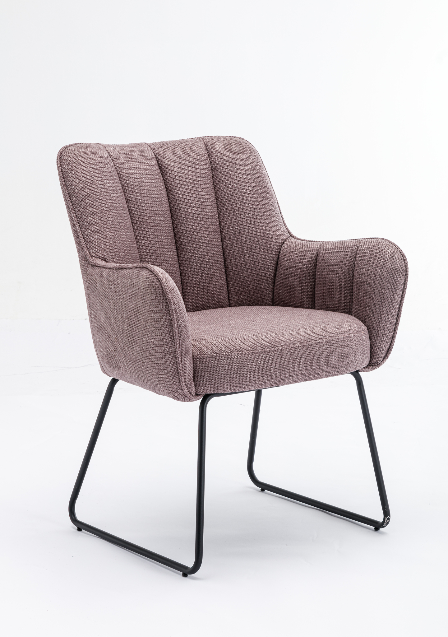 De Stoel Kevin Bjorn Fabric Lavender is een moderne fauteuil met lavendelkleurige bekleding, verticale stiksels op de rugleuning en armleuningen en zwarte metalen sledepoten, tegen een effen witte achtergrond.