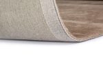 Close-up van de rand van het Rome Beige 02 200x300 tapijt met de hoek iets opgetild, waardoor het beige gestructureerde oppervlak, de onderkant en de dikte van het materiaal zichtbaar worden tegen een witte achtergrond.