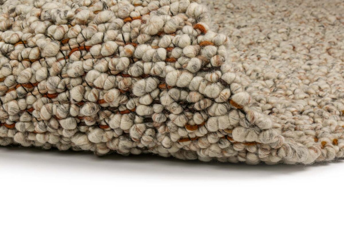 Close-up van het Modena Cloud White 115 200x300 tapijt, met getextureerde lussenpool wol en dikke ronde garens in beige, grijze en bruine tinten met een gevouwen hoek op een witte achtergrond.