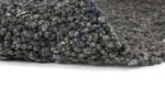 Een close-up van het Modena Grey 916 200x300 tapijt toont gestructureerde, grofgebreide lussen in grijs met vleugjes blauwe en beige vezels, gedeeltelijk omgevouwen op een witte achtergrond.