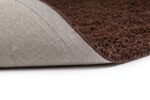 Een close-up van de Berbero Lungo Natural Beige 522 200x300 deurmat met de hoek omhoog, waardoor het beige oppervlak met textuur aan de bovenkant en de grijze achterkant aan de onderkant goed uitkomen tegen een witte achtergrond.