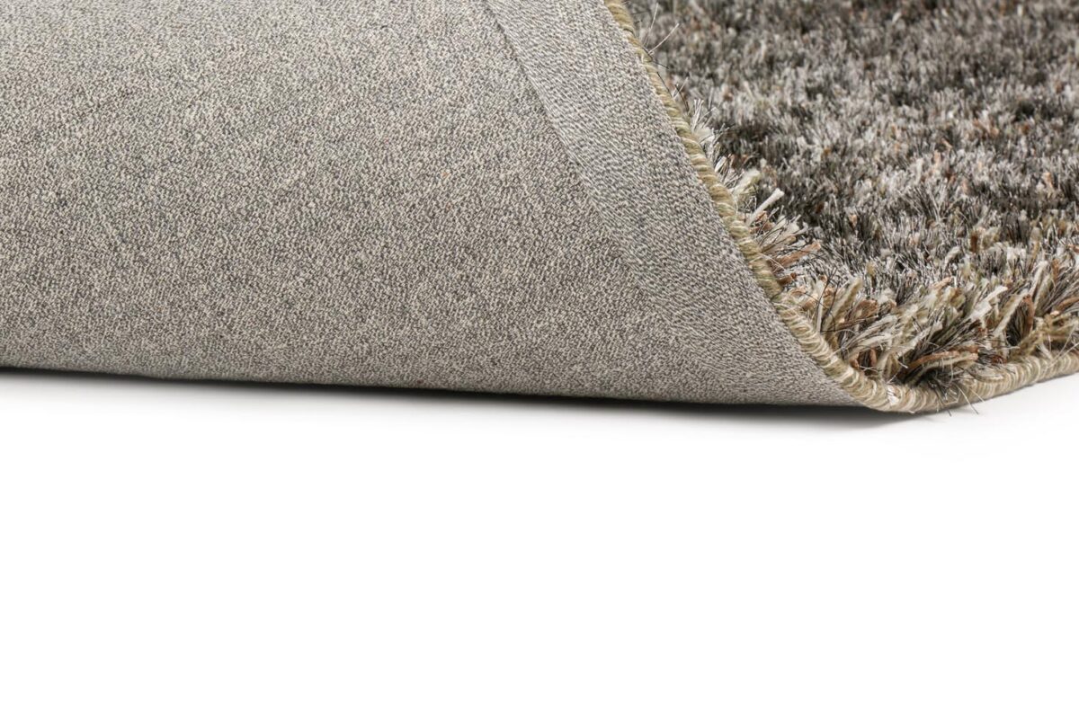 Een close-up van het New Paulo Grey mix 862 200x300 tapijt met een hoek opgetild, waardoor de gestructureerde rug en dikke, zachte pool aan de bovenkant zichtbaar worden.