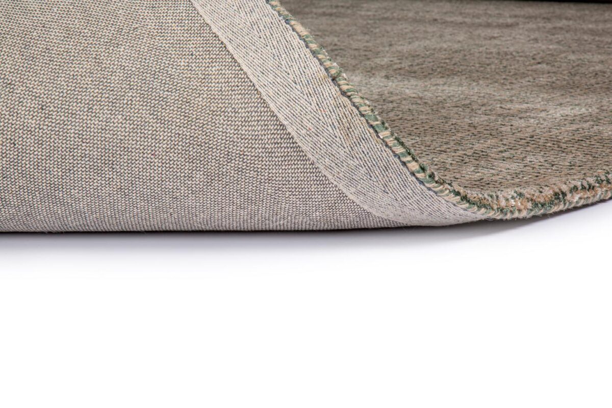 Close-up van het beige Rome Green 06 200x300 tapijt, met een hoek omgedraaid om de gestructureerde achterkant en gestikte rand te onthullen, tegen een witte achtergrond.