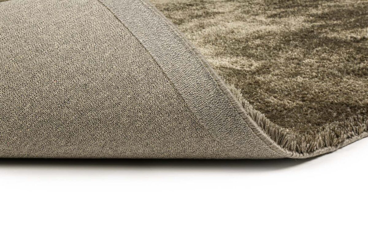Close-up van de omgeslagen hoek van het Viterbo ST Dark Grey 831 200x300 tapijt, met de gestructureerde achterkant en zachte, pluche donkergrijze pool tegen een witte achtergrond.