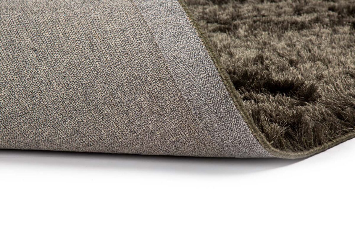 Close-up van het Arezzo ST Hunter 421 200x300 tapijt met een omgedraaide hoek, waardoor de gestructureerde rug en de donkere, pluche poolvezels zichtbaar worden tegen een witte achtergrond.