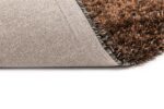 Een close-up van het New Paulo Anthracite mix 770 vloerkleed in 170x230, gedeeltelijk gevouwen om de getextureerde, antisliprug tegen een wit oppervlak te laten zien.