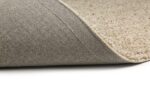 Een close-up van het Berbero Lungo Cloud White 815 170x230 beige tapijt, met het oppervlak met textuur en een opgelichte hoek om de antislip grijze tapijtrug op een witte ondergrond te onthullen.
