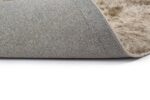Een close-up van het Arezzo ST Silver 119 200x300 tapijt, met grijze stof met textuur aan de bovenkant en zacht beige materiaal aan de onderkant, gedeeltelijk gevouwen om beide oppervlakken te onthullen tegen een witte achtergrond.
