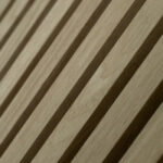Close-up van Akupanel Eiken Naturel 60 x 60 cm wandpanelen, met gelijkmatig verdeelde verticale latjes voor een gestructureerde geometrische look met schaduwrijke ribbels.