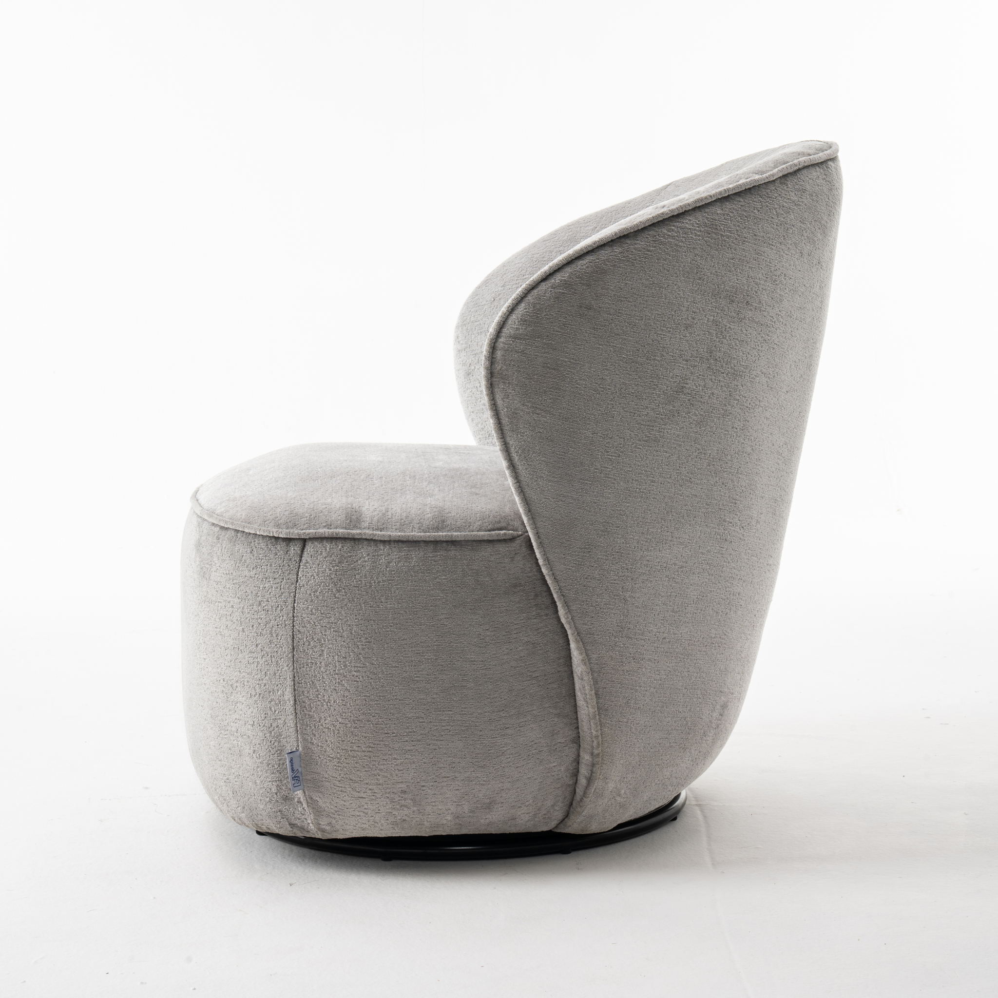 De Sammy Draaifauteuil Stof Loris #08 Grey, een moderne pluche draaistoel met een ronde rug en vloeiende rondingen, wordt van opzij getoond tegen een effen witte achtergrond. De lichtgrijze bekleding is gemaakt van zachte, gestructureerde stof.