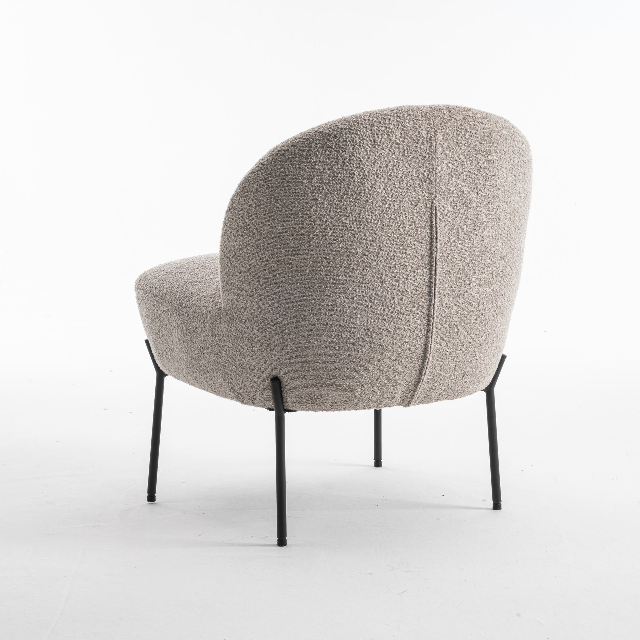 De Baudin fauteuil Stof Teddy Natural 01 is een moderne accentstoel met een afgeronde rugleuning en zitting in beige stof met structuur, ondersteund door vier slanke zwarte metalen poten, afgebeeld op een witte achtergrond.