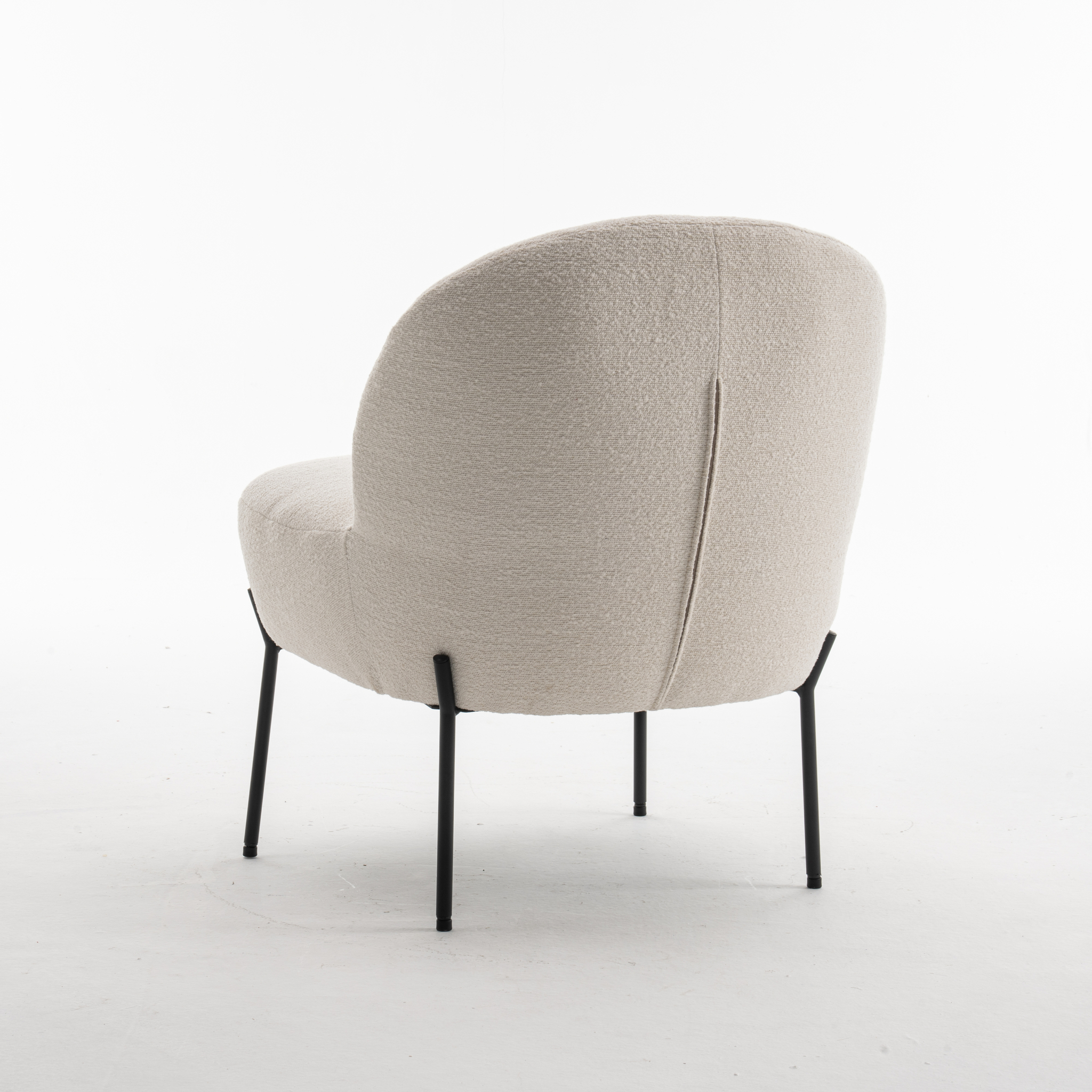 De Baudin fauteuil Stof Teddy Ivory 101 heeft een modern ontwerp met een afgeronde rugleuning en zitting in licht ivoorkleurige teddystof, ondersteund door vier slanke zwarte metalen poten. Afgebeeld tegen een effen witte achtergrond.