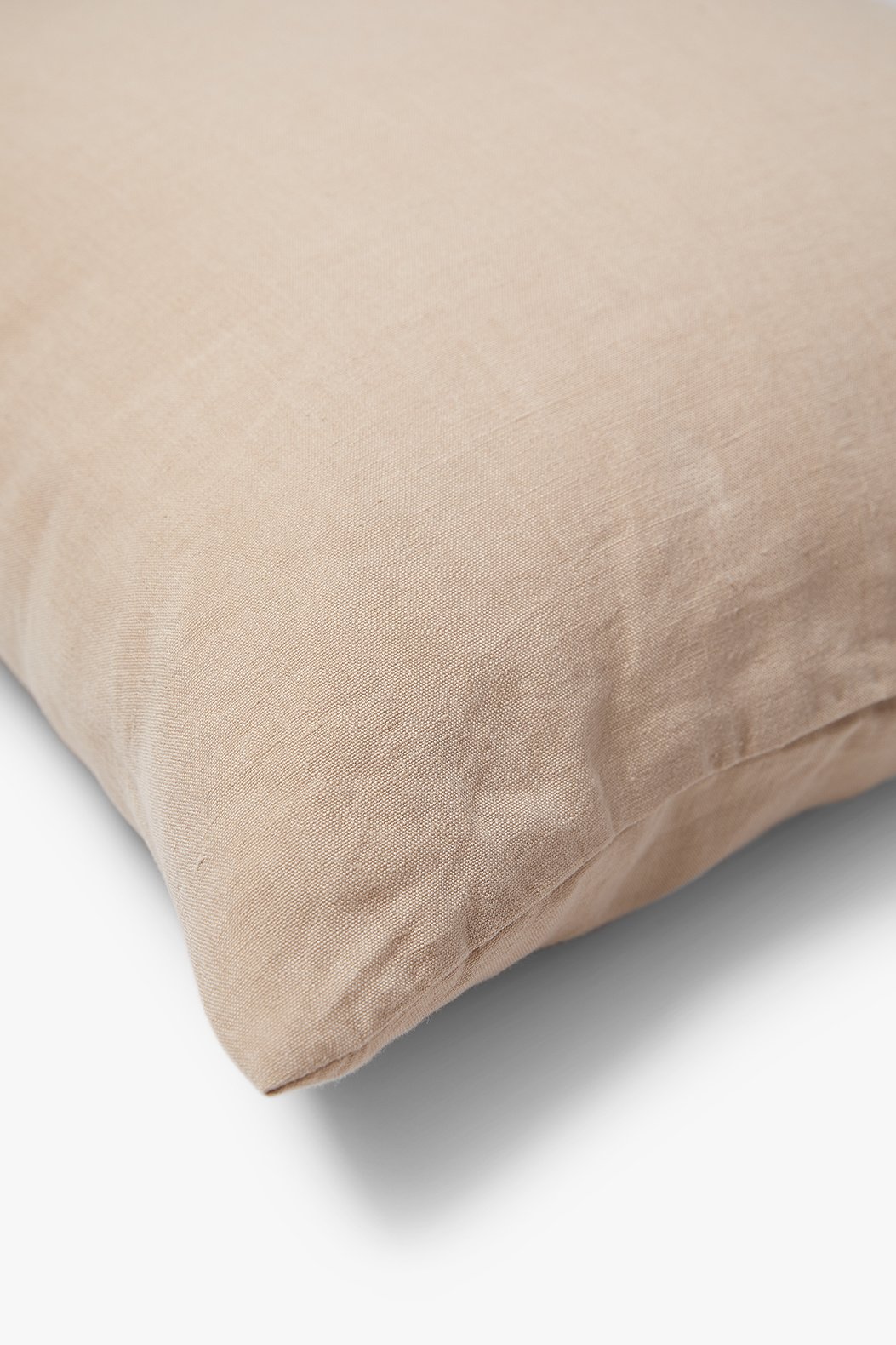 Een close-up van de Sierkussenhoes Scotty Nude 60x40 cm, met een zachte, linnenachtige beige textuur tegen een witte achtergrond.