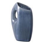 De vaas is een hoog, modern stuk van blauw keramiek met een glanzende afwerking, met een ovale opening aan de bovenkant en een grote ronde opening aan de zijkant voor decoratie of om het makkelijk te hanteren.