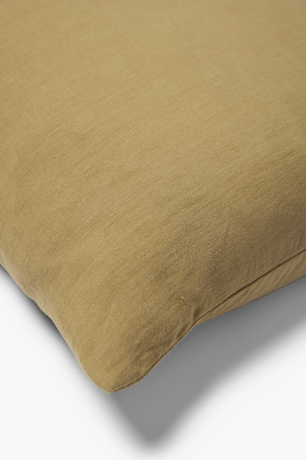 Een close-up van het Sierkussenhoes Scotty Goudbruin 60x40 cm, een lichtbruine rechthoekige kussenhoes met een gladde stofstructuur, afgebeeld tegen een witte achtergrond.