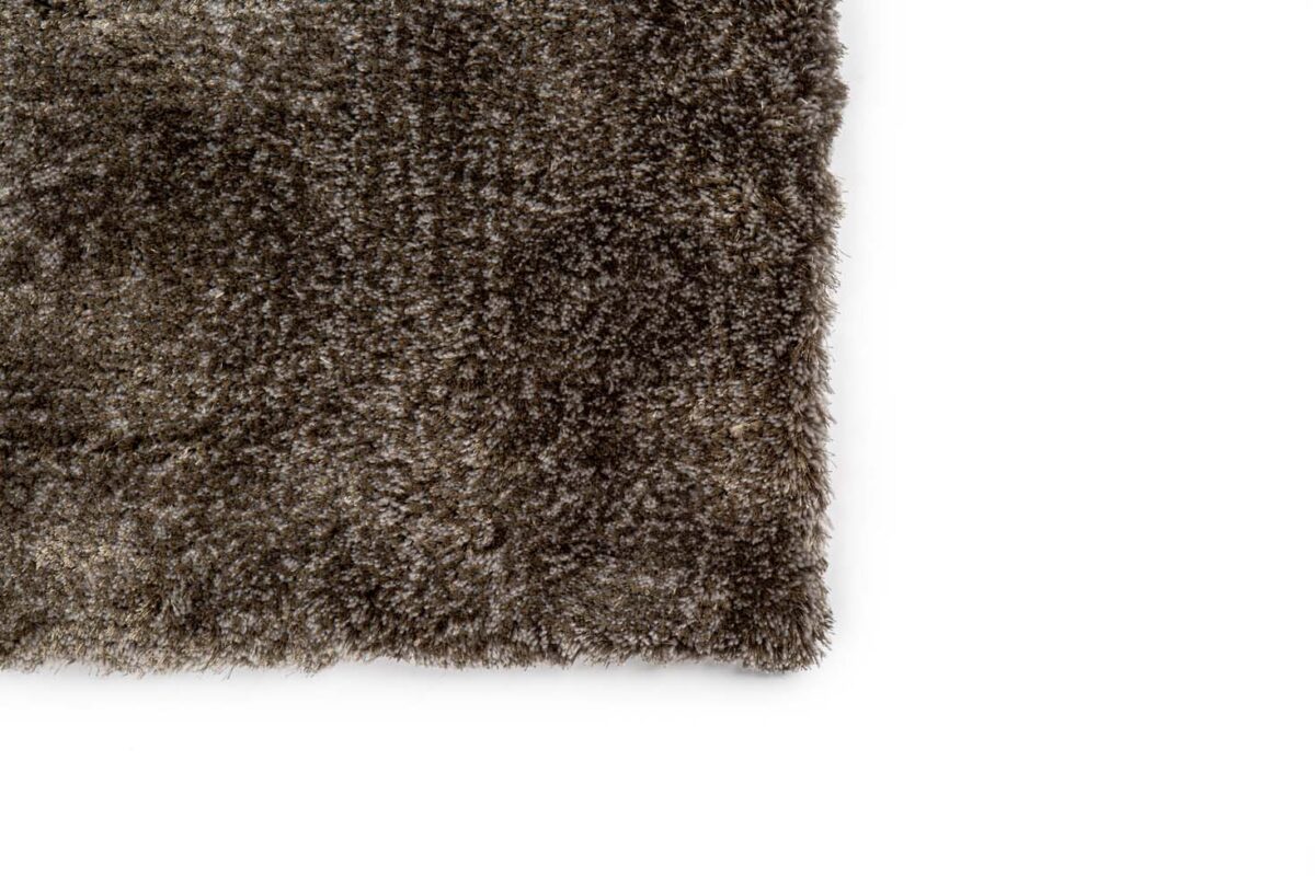 Een close-up van de hoek van het zachte, ruige tapijt Viterbo ST Dark Grey 831 170x230 tegen een witte achtergrond.
