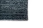 Close-up van de hoek van het Portofino Blue 01 200x300 vloerkleed, met een donkerblauw en grijs geweven dessin op een witte achtergrond.