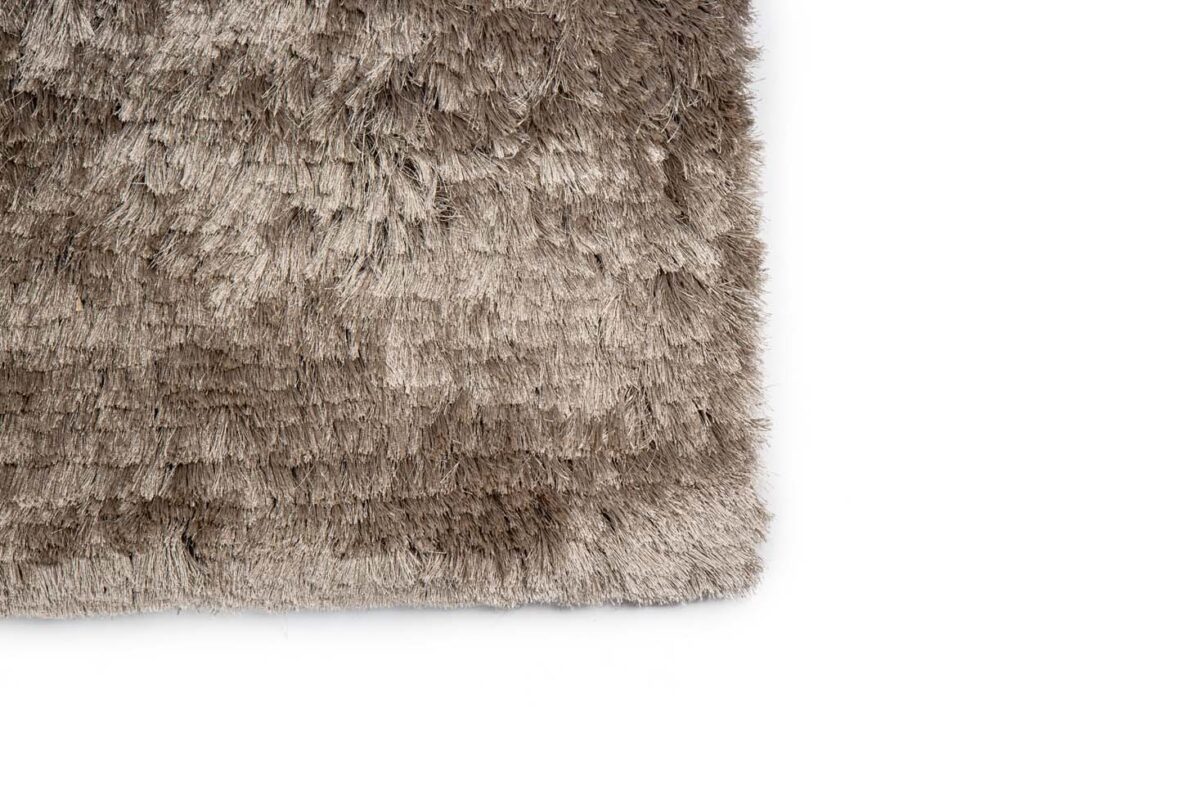 Close-up van de hoek van het Arezzo ST Grey 803 200x300 shaggy vloerkleed met textuur op een witte achtergrond.