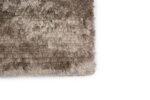 Close-up van de hoek van het Arezzo ST Grey 803 200x300 shaggy vloerkleed met textuur op een witte achtergrond.